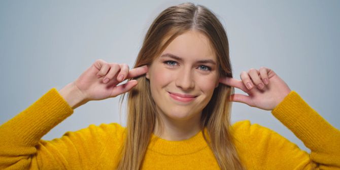 Frau hält Ohren zu