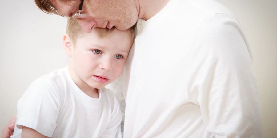 Vater tröstet traurigen Jungen