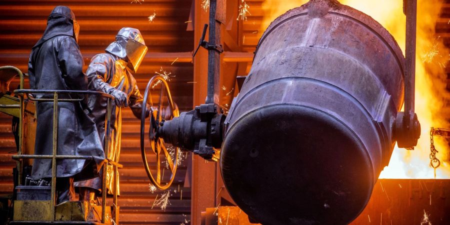 Arbeiter giessen flüssiges Eisen mit einer Temperatur von 1.400 Grad in der Eisengiesserei Torgelow in vorbereitete Formen.