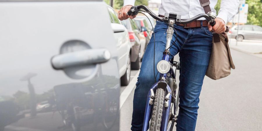 Gefährliche Unaufmerksamkeit: Wer seine Autotür öffnet, muss sicherstellen, dass niemand gefährdet wird. Ein einfacher Trick hilft, die Aufmerksamkeit vor dem Aussteigen nach hinten zu lenken.