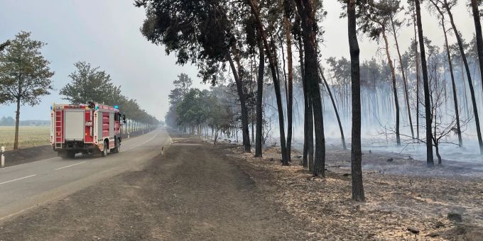 Ein Feuerwehrwagen fährt zwischen Kosilenzien und Nieska im Landkreis Elbe-Elster an einem abgebrannten Wald vorbei. Ein Feuerwehrwagen fährt zwischen Kosilenzien und Nieska im Landkreis Elbe-Elster an einem abgebrannten Wald vorbei.