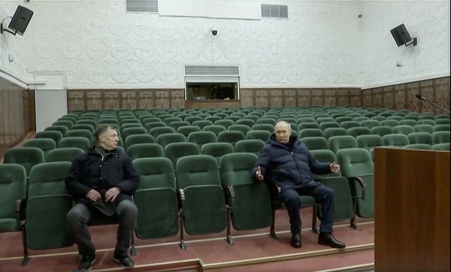 Das Staatsfernsehen zeigte auch den Besuch Putins in der Philharmonie von Mariupol, wo der Präsident auf einem Stuhl in einem Saal Platz nahm.