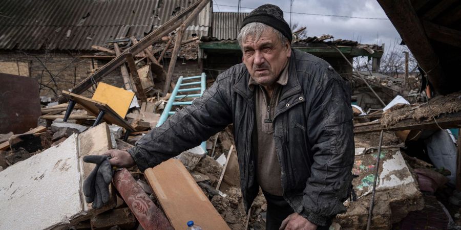 Mykola Volenshak sieht sich sein von einer russischen Rakete zerstörtes Haus an, während er versucht, Dokumente unter den Trümmern zu finden.