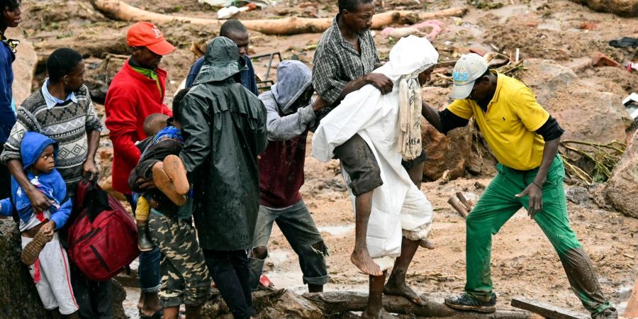 Ein verletzter Mann wird in Malawi über eine Behelfsbrücke getragen.