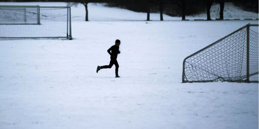 Naherholungsgebiet: Ein Jogger auf der verschneiten Allmend.