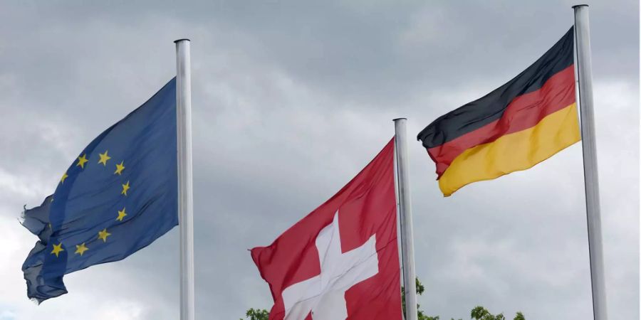 Die europäische, die Schweizer und die deutsche Flagge sind am Grenzübergang an der A5 an der Schweizer Grenze bei Weil am Rhein (D) zu sehen.