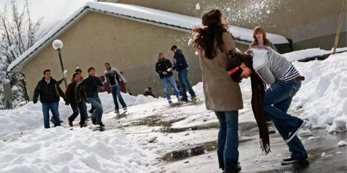 Aufgrund der erwartet schlechten Wetterlage fällt der Unterricht am Montag und Dienstag aus. (Symbolbild) Kinder spielen während der Pause im Schnee.