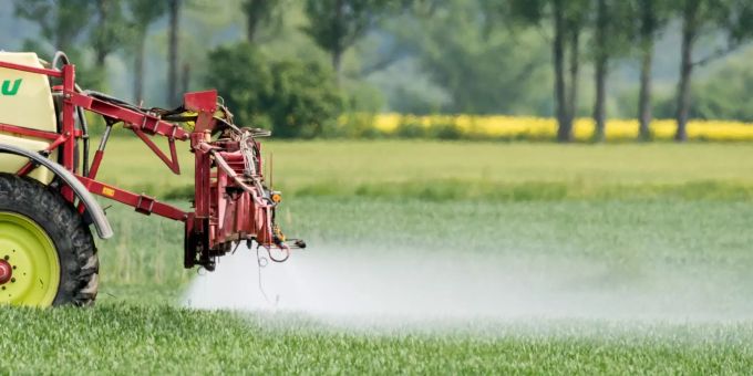 Ein Traktor mit einer Spritzmaschine. pesitzid