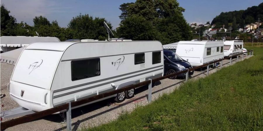 Mehrere Wohnwagen auf einem Platz.