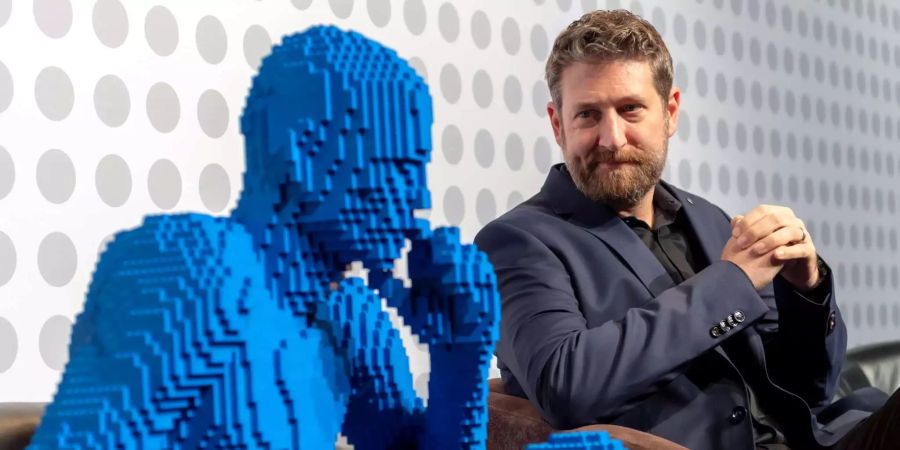 Nathan Sawaya sitzt neben einer Skulptur aus seiner Lego-Ausstellung «The Art of the Brick».