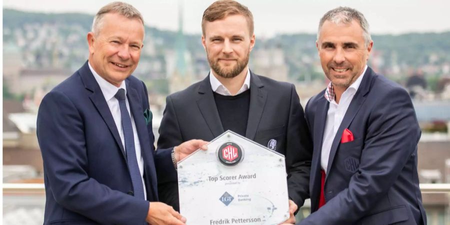 Stephan Züger, Regionenleiter LGT (l.) und Matin Baumann, CEO Champions Hockey League überreichen Frederik Pettersson den besten Topscorer der Champions Hockey League.