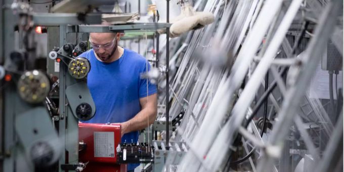 Ein Arbeiter betreibt Webstühle. arbeiter