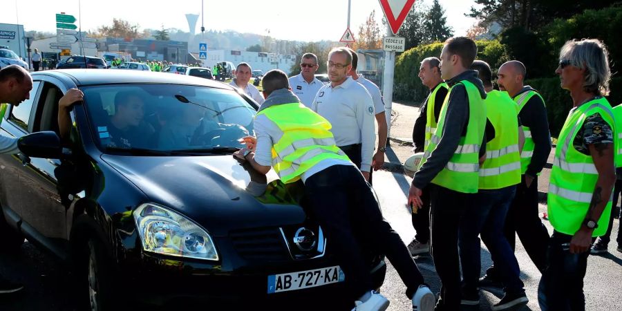 Französische Demonstranten blockieren bei einem Protest gegen zu hohe Spritpreise ein Auto.