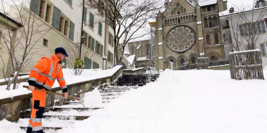 Ein Arbeiter schaufelt in Lausanne Schnee weg.