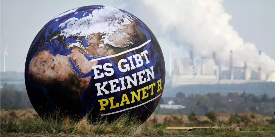 Ein Ballon mit der Aufschrift «Es gibt keinen Planet B» ist vor Braunkohlekraftwerken zu sehen.