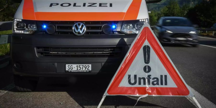 Unfall Warndreieck auf der Strasse neben einem Polizeiwagen.