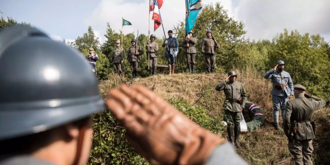 Männer in Uniformen aus dem Ersten Weltkrieg spielen die Schlacht in Verdun nach.