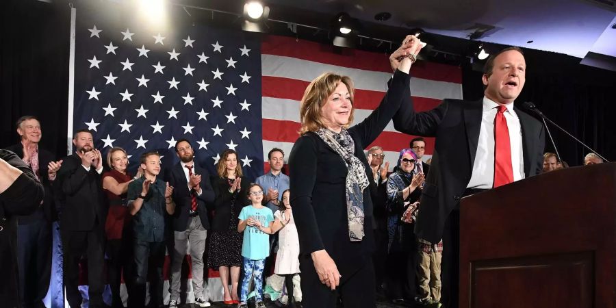 Der neue Gouverneur Colorados Jared Polis hält die Hand von Dianne Primavera während seiner Antrittsrede.