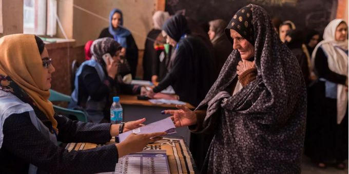 Eine afghanische Wählerin nimmt ihren Stimmzettel für die Parlamentswahlen in einem Wahllokal entgegen. Eine afghanische Wählerin nimmt ihren Stimmzettel für die Parlamentswahlen in einem Wahllokal entgegen.
