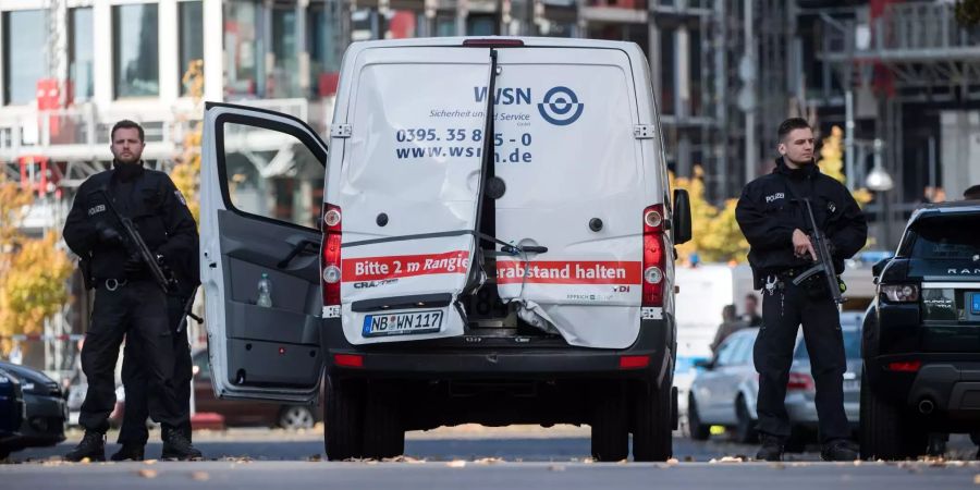 Polizisten mit Maschinenpistolen sichern in Berlin einen Geldtransporter mit aufgebrochenen Türen in Mitte.