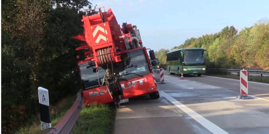 Ein roter 60 Tonnen schwerer Autokran ist von der Fahrbahn in den Grünstreifen gerutscht.