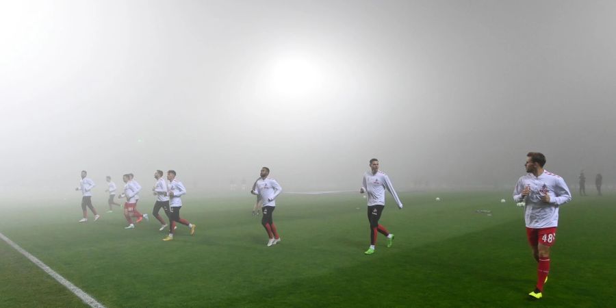 Die Kölner Spieler wärmen sich im dichten Nebel vor dem Spielabbruch auf.
