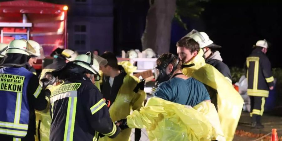 Feuerwehrleute stehen an einer Sammelstelle für die Rettungskräfte beim Gebäude der nordrhein-westfälischen Staatsanwaltschaft. Foto: Alex Talash/dpa