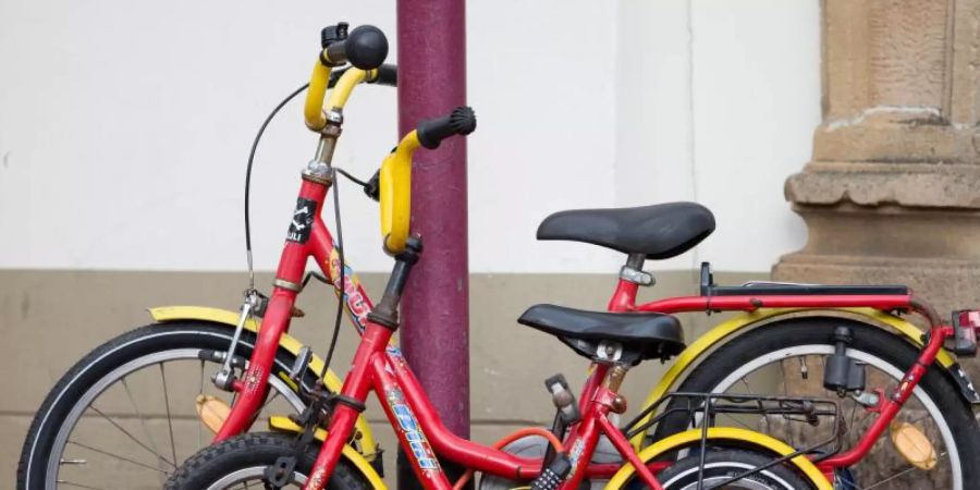 Zwei zusammengeschlossene Kinderfahrräder an einer Strassenlaterne. In Mailand hat ein Sechsjähriger von der Polizei eine neues Rad bekommen. Foto: Friso Gentsch/dpa