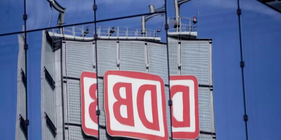 Das Logo der Deutschen Bahn AG spiegelt sich in Berlin in einer Gebäudefassade. Foto: Christoph Soeder/dpa