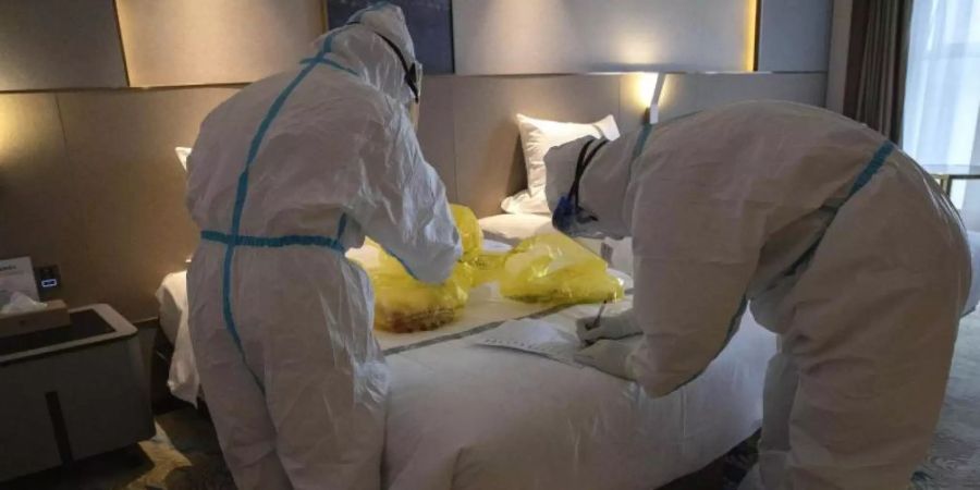 Probensammlung in einem Hotel in China. Hier leben Menschen unter Quarantäne, die auf Covid-19 getestet werden sollen. Foto: Ng Han Guan/AP/dpa