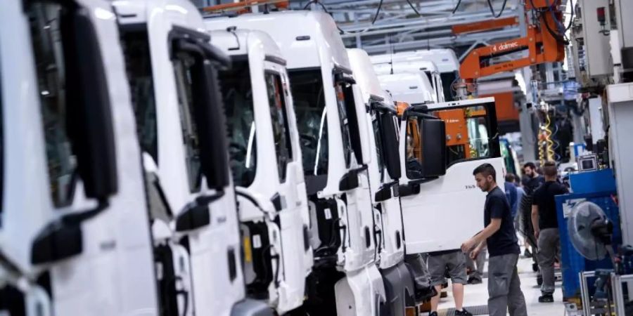 Mitarbeiter von MAN Truck & Bus arbeiten an einer Produktionsstrasse in München. Die Traton-Tochter hat seine Werke in Europa geschlossen. Foto: Sven Hoppe/dpa
