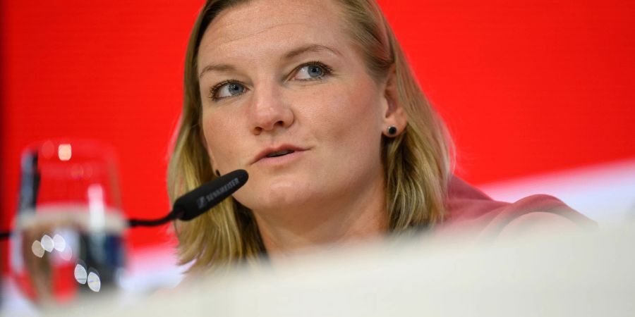 Nationalspielerin Alexandra Popp sitzt während einer Pressekonferenz auf dem Podium.