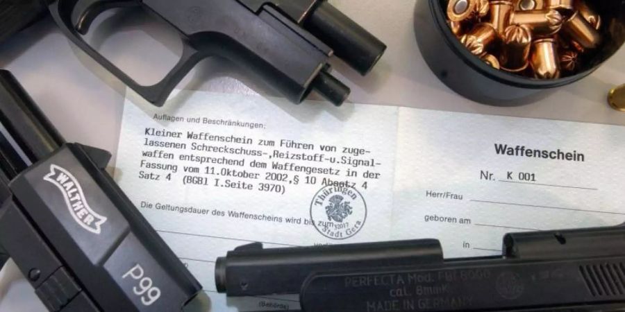 Das Muster eines so genannten Kleinen Waffenscheins ist neben Schreckschusswaffen und der dazugehörigen Munition ausgestellt. Foto: Jan-Peter Kasper/Symbolbild
