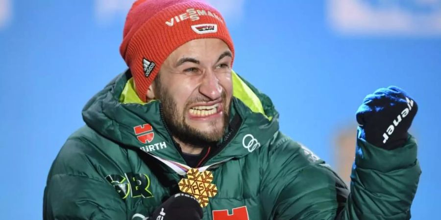 Skiskringer Markus Eisenbichler freut sich bei der Siegerehrung über seiner WM-Goldmedaille. Foto: Hendrik Schmidt
