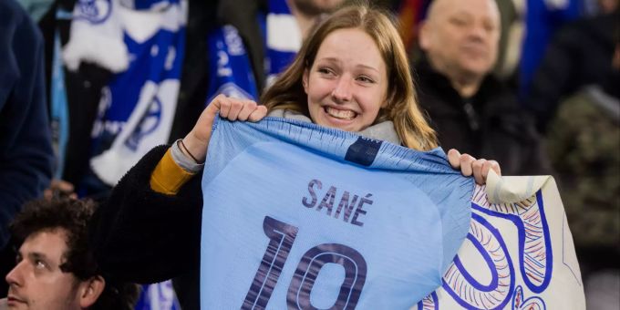 Ein Fan von Schalke freut sich über das Trikot von Leroy Sané. Mädchen mit Sanés Trikot.
