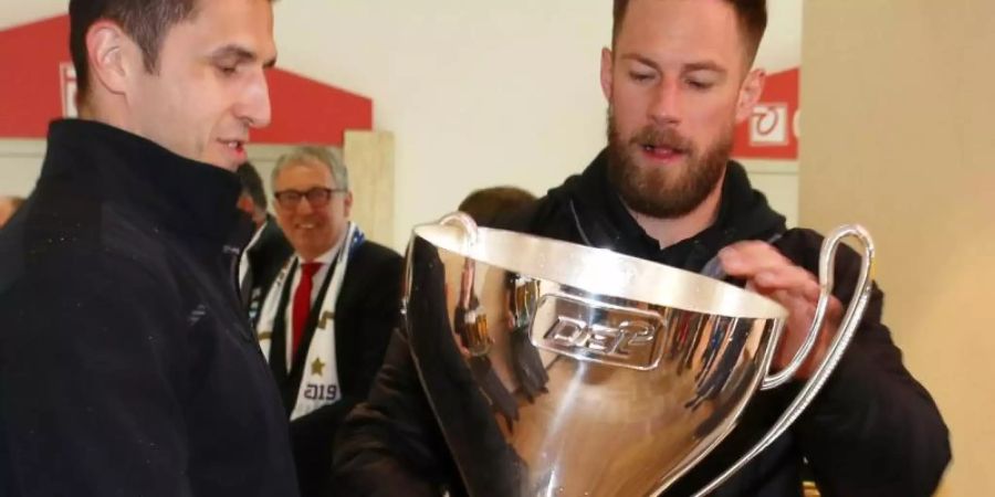 Marcel Goc (l) und Markus Kink begutachten den beschädigten Pokal. Foto: Michael Deines