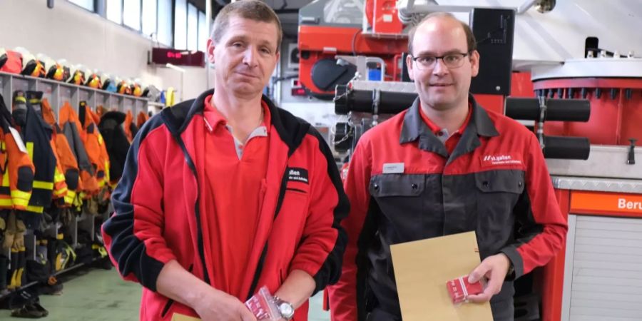 Zwei Mitarbeiter halten ihre Beförderung in den Händen