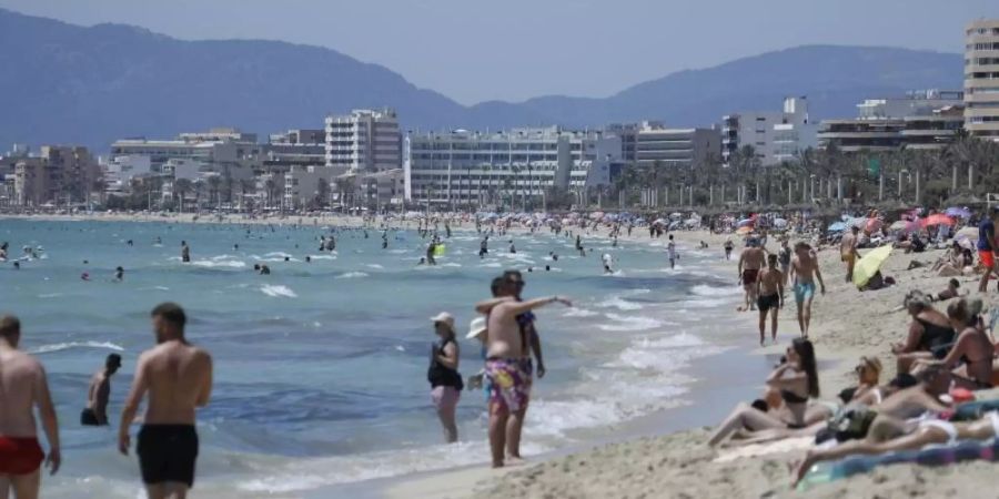 Touristen am Strand von Arenal in Palma de Mallorca - trotz steigender Corona-Zahlen. Foto: Clara Margais/dpa