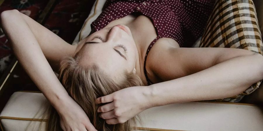 Frau liegt auf Sofa