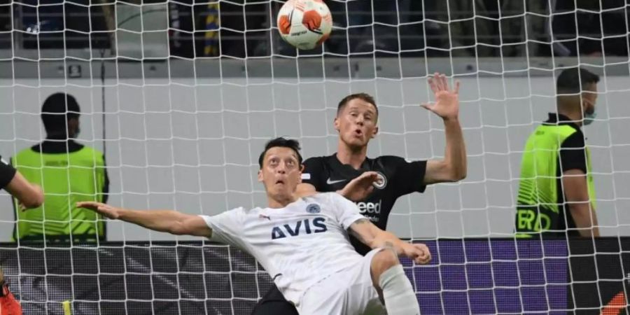 Frankfurts Erik Durm (r) und Istanbuls Mesut Özil kämpfen um den Ball. Foto: Arne Dedert/dpa