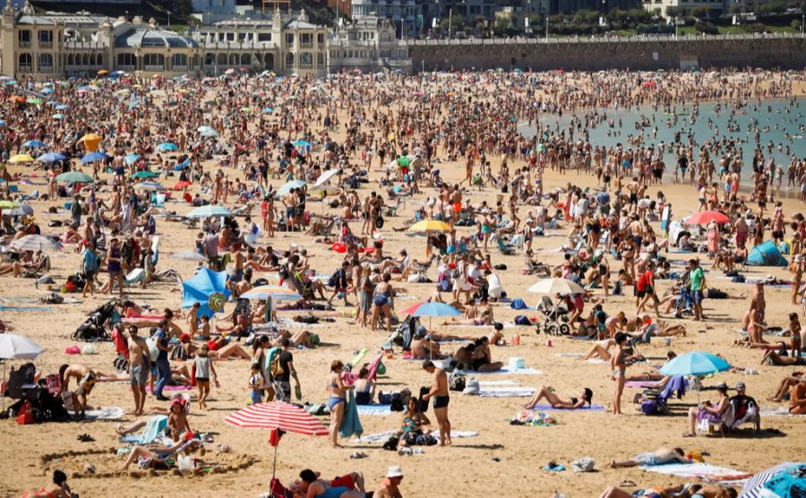 Badegäste an einem spanischen Strand. Trotz Corona raten die Reiseanbieter zur frühzeitigen Ferien-Planung.