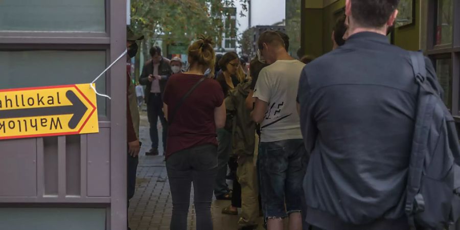 Wahlberechtigte warten nach 18 Uhr in einer Schlange vor einem Wahllokal an der Mandelstrasse im Berliner Stadtteil Prenzlauer Berg darauf, ihre Stimmen zur Bundestagswahl, der Abgeordnetenhauswahl und der Wahl der Bezirksvertretungen abgeben zu dürfen. Foto: Georg Hilgemann/dpa-Zentralbild/dpa