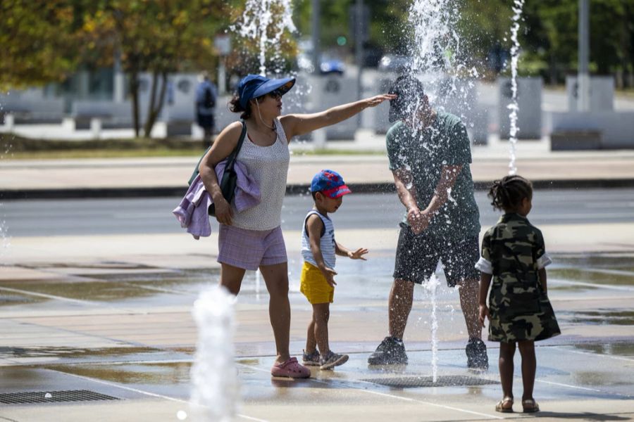 Eine Familie kühlt sich in Lausanne ab. Dort war es am Samstag 30 Grad.