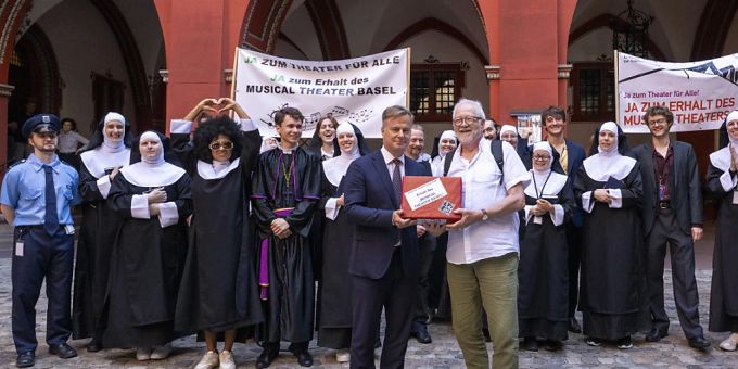 Toni Kleimann (vorne rechts), Initiant des Volksbegehrens zum Erhalt des Musical Theater Basel, übergibt in Begleitung des Musical-Ensembles «Sister Act» dem Basler Vizestaatsschreiber Marco Greiner die Unterschriften. Toni Kleimann (vorne rechts), Initiant des Volksbegehrens zum Erhalt des Musical Theater Basel, übergibt in Begleitung des Musical-Ensembles «Sister Act» dem Basler Vizestaatsschreiber Marco Greiner die Unterschriften.