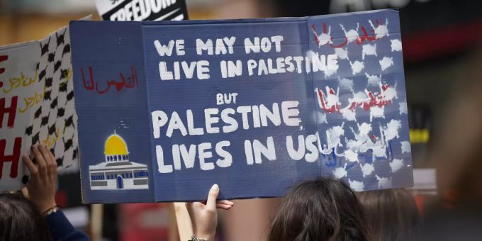 22.05.2021, Grossbritannien, London: Eine Demonstrantin hält während eines Protestes in Solidarität mit Palästina ein Schild mit der Aufschrift «We may not live in Palestine but Palestine lives in us» (dt. Wir leben vielleicht nicht in Palästina, aber Palästina lebt in uns) in die Höhe, nachdem es zu einer Waffenruhe im Nahostkonflikt gekommen ist. Foto: Yui Mok/PA Wire/dpa +++ dpa-Bildfunk +++ Konflikt in Nahost - Demonstration in London