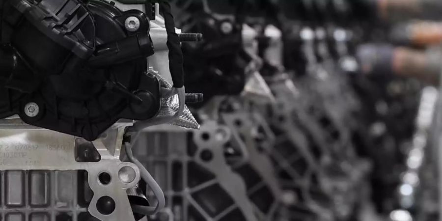Motoren werden in einem Motorenwerk über die Fertigungslinie gefahren. Foto: Hendrik Schmidt/dpa-Zentralbild/dpa