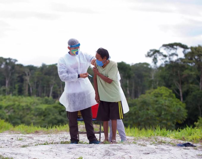 03.03.2021, Brasilien: Ein Mitarbeiter des Gesundheitsministeriums verabreicht einem indigenen Mann eine Impfung gegen das Coronavirus. Coronavirus - Brasilien