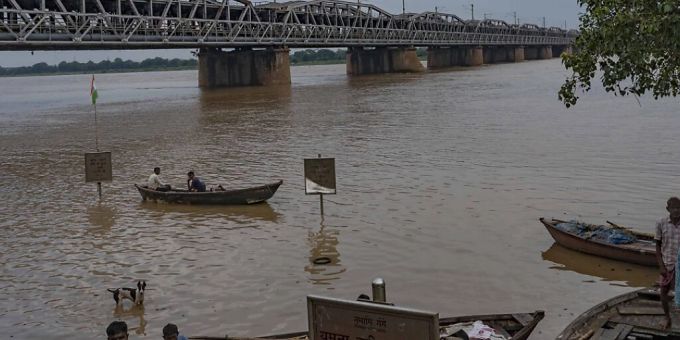 Bootsführer stehen nach starken Regenfällen am Ufer des Flusses Yamuna, dessen Wasserspiegel nach schweren Regenfällen stark angestiegen ist. (Symbolbild) Foto: Rajesh Kumar Singh/AP/dpa Sturzflut in Indien