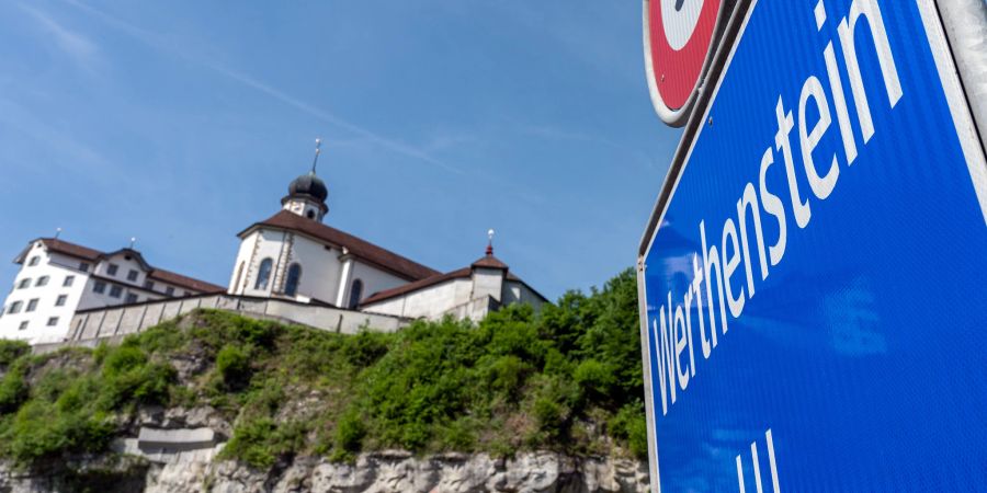 Die Ortstafel Werthenstein mit Wallfahrtskirche und Kloster Werthenstein im Hintergrund.