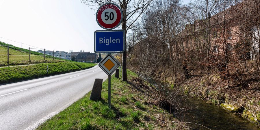 Das Dorfschild von Biglen an der Rohrstrasse. Rechts der Biglenbach.